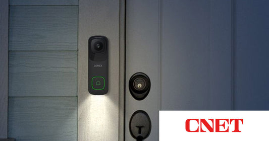 Lorex 4K Wired Video Doorbell mounted beside a front door at night with built-in night light illuminated, featured in CNET’s roundup of the best video doorbells of 2026.