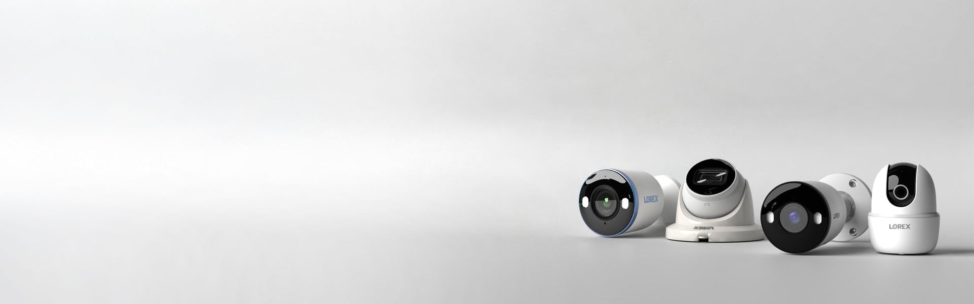A banner featuring a collection of Lorex security cameras, including dome, bullet, and pan-tilt models, arranged on a minimalistic white background. The sleek designs showcase advanced features for home and business surveillance, emphasizing versatility and modern aesthetics.