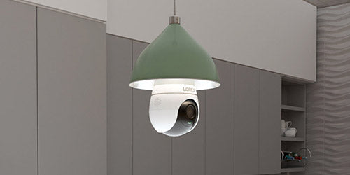 Lorex 2K lightbulb security camera installed in a pendant light fixture within a modern kitchen