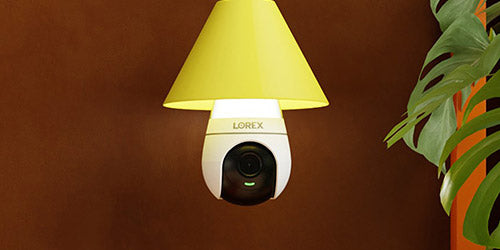 Lorex lightbulb camera with a yellow lampshade, shown in a modern room setup for indoor security and smart home monitoring.